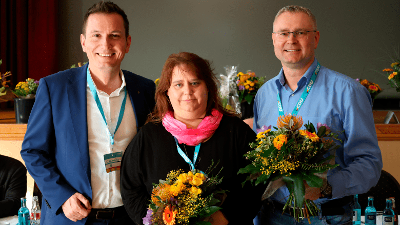 Sven Czekalla, neuer Kreisvorsitzender der CDU Saalekreis, mit seinen Stellvertretern Antje Mutschler-Mittmann und Christian Runkel, alle mit Blumensträußen.